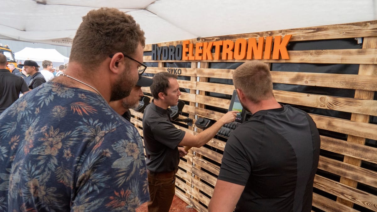 Návštěvníci si u stánku zkoušejí ovládací panel a baví se s obsluhou expozice